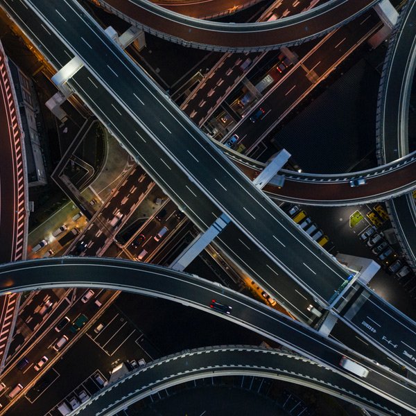 a freeway at night with a few cars driving around